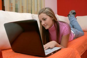 Teenager girl on the loundge and using notebook computer